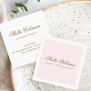 Front and back of feminine square business cards. The front has a light blush pink center framed by a white double border, containing calligraphy and sans-serif text for a name and title. The back shows a matching calligraphy name and sans-serif text stack at the top, followed by a neatly organized vertical list of contact information on a clean white background.