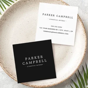 Modern minimalist business cards featuring a black front with white serif typography, and white back with custom contact information.