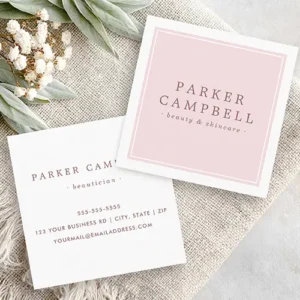 Square beauty business card. The front shows a soft blush pink panel with a double white line border and elegant dusty rose serif text for name and title or business name. The back shows a clean white background with centered dusty rose contact information.