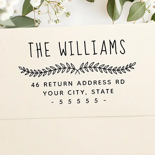 Custom stamp featuring a hand-drawn style family name header, a central botanical leaf sprig divider, and clean, text lines displaying a custom street address, city, state, and zip code.