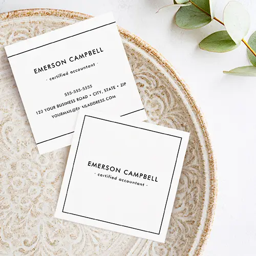 Front and back views of a classic white square business card. The front is white with a precise thin black square frame enclosing centered custom name and title details. The back simplifies the design to top and bottom border lines, with repeated name and title text at the top and contact details (phone, address, email) stacked below in a clean, professional sans-serif font.