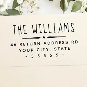 Rubber stamp featuring a hand-lettered custom family surname header, a central, vintage style diamond divider line, and structured address and zip code text lines at the bottom.