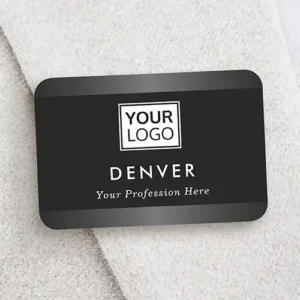 Black plastic name pin with rounded corners featuring dark gradient top and bottom bands, a central custom logo, stacked employee name text, and an italicized title line.