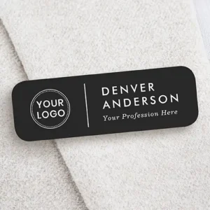 Black rectangular plastic name pin displaying a custom logo on the left, a vertical divider bar, stacked uppercase employee name, and an italic job title line.