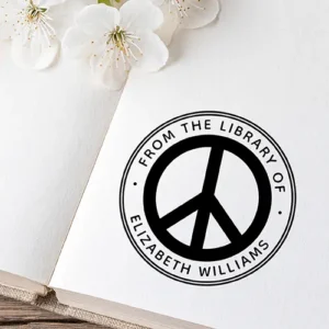 Round self-inking stamp featuring a bold peace symbol graphic enclosed by a double border and curved custom library owner text.