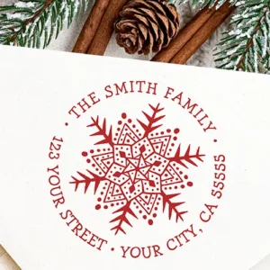 Round rubber stamp design featuring a central hand-drawn mandala snowflake illustration encircled by arched typewriter-style custom name and address text.