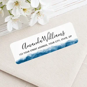 Horizontal rectangular white address sticker featuring an indigo blue watercolor wash along the bottom margin and black calligraphy script name text above a sans-serif address line.