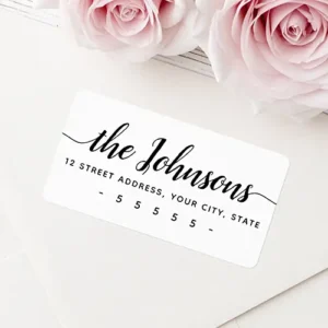 Rectangular white return address sticker featuring flowing cursive family name script with side flourishes above crisp black address text.