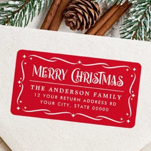 Rectangular address sticker featuring a red background with white decorative scrollwork border and stars surrounding a Merry Christmas headline and white address text.