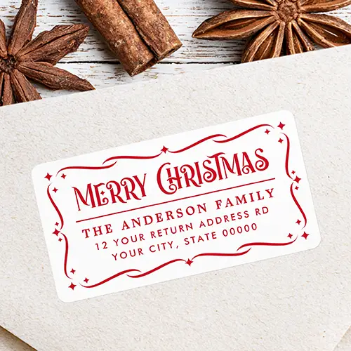 White rectangular return address sticker enclosed in a red filigree scrollwork frame with starbursts, featuring vintage "Merry Christmas" typography above a horizontal line divider and custom red address text.