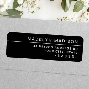 A horizontal rectangular sticker label with rounded corners on a solid black background. On the top right, a full name is printed in white sans-serif text above a thin white horizontal line, with three right-aligned address lines printed below.