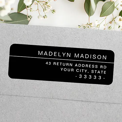 A horizontal rectangular sticker label with rounded corners on a solid black background. On the top right, a full name is printed in white sans-serif text above a thin white horizontal line, with three right-aligned address lines printed below.