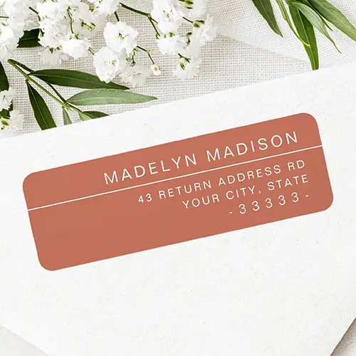 Horizontal terracotta brown self-adhesive address label featuring crisp white uppercase lettering, a thin dividing line, and right-aligned address details.