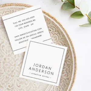 Two custom square business cards displaying front and back views. The front is a clean white square with a precise thin black square border framing centered name and title text in clean black fonts. The back is white with thin horizontal black lines near top and bottom, framing centered stacked blocks of contact and social media information in black. All fonts are clean sans-serif.