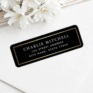 Rectangular address sticker featuring a solid black background framed by a faux gold gradient printed border with centered white serif name and sans-serif address typography.