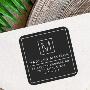 Square black return address label sticker featuring a white border, central initial monogram box, custom name line, and address block in clean white typography.