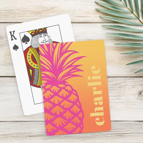 Playing cards featuring a large pink and orange pineapple illustration on a warm gradient background, with customizable name or text in vertical light yellow text on the right.