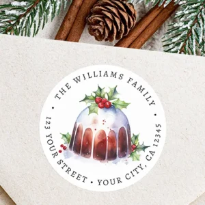 Round white holiday return address sticker featuring a central watercolor illustration of a Christmas pudding cake with icing and holly berries, encircled by arched custom serif address typography.