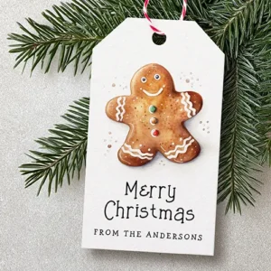 Vertical white gift tag featuring a central watercolor gingerbread man cookie with icing details above black "Merry Christmas" text and a custom sender name.