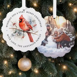 Scalloped round double-sided paper ornament card featuring a watercolor red cardinal on a snowy branch with arched holiday text on one side and a custom photo on the other.