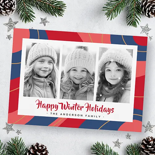 Horizontal holiday greeting card featuring a border and reverse side of abstract red, blue, and pink swirls framing three black-and-white photos and red script text.