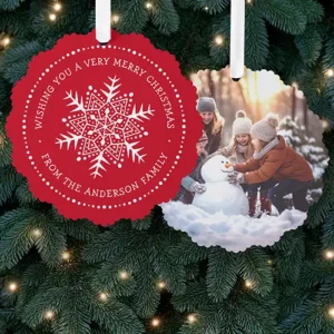 Scalloped round double-sided paper ornament card featuring a detailed white snowflake illustration with arched holiday text on a bright red background on side one and a custom portrait photo on side two.