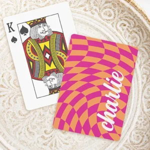 A playing card featuring a wavy, distorted psychedelic checkerboard pattern in alternating hot pink and bright orange squares. On the right side, a custom name is written vertically in a thick, flowing white script font.