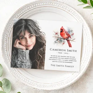 Horizontal flat memorial card featuring a portrait photo field on the left and a watercolor style red bird illustration above custom name, dates, and text on the right.