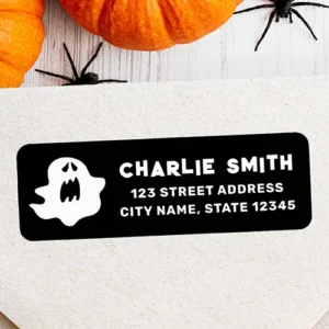 Horizontal black self-adhesive address label featuring a white floating ghost illustration alongside custom name and crisp address text.