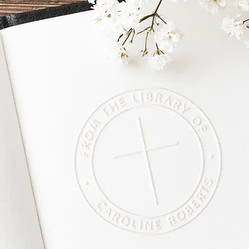 Personalize your home library with a round Christian cross book embosser seal. Features a minimalist cross & custom name typography. Order online!