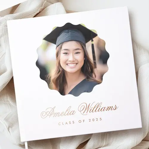 A white hardcover personalized graduation guest book. Features a large scalloped-edge circular photo frame for your custom photo and personalized text in elegant rose gold real foil.