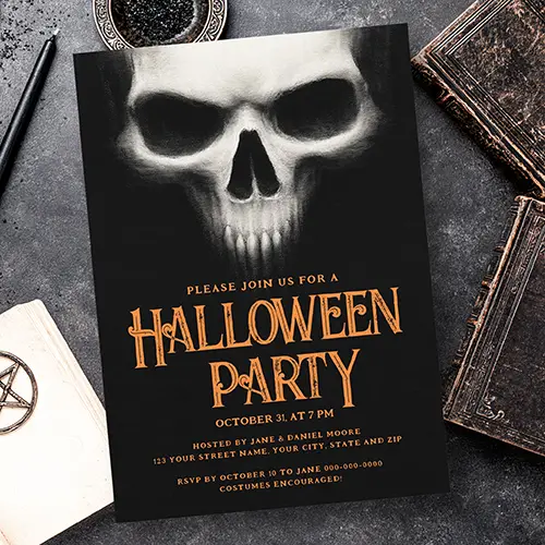 Dark Halloween card featuring a textured white and grey skull face on a black background, paired with orange event typography for date, location, and RSVP details.