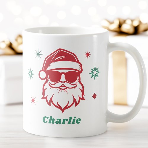 Personalized Christmas ceramic mug with watercolor Santa illustration, red stars, and custom name text. Cute holiday coffee cup gift for kids and adults.