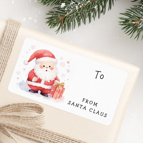 Watercolor Santa Claus gift label featuring a cute Santa in a red suit holding a present with a golden bow, surrounded by festive snowflakes and stars. Includes “To” and “From Santa Claus” text for easy Christmas gift labeling.