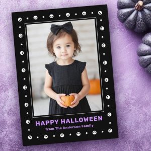 Custom Halloween greeting card with black skull and star border, purple Happy Halloween text, and family name. Includes space for a personal photo.