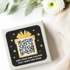 Black and gold QR code sticker featuring a printed color image gold gift box and stars on a black background with customizable text area. Perfect for business branding or packaging.