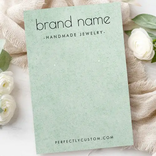 A minimalist sage green earring display card with a subtle printed speckled texture. The front features your brand name and URL or other custom text with logo on the back.