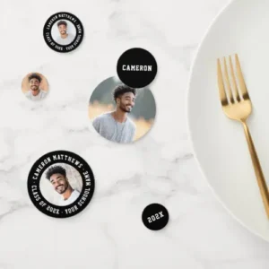 A close-up view of a variety of round table confetti pieces scattered on a marble surface.