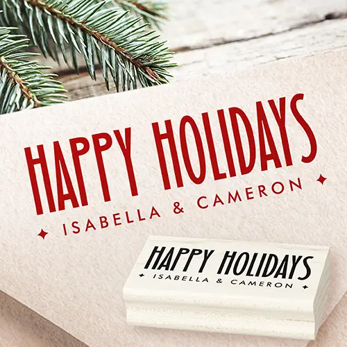 An ink rubber stamp featuring tall, elongated condensed uppercase letters spelling Happy Holidays above a widely spaced second line of custom text flanked by four-point diamond starburst symbols.