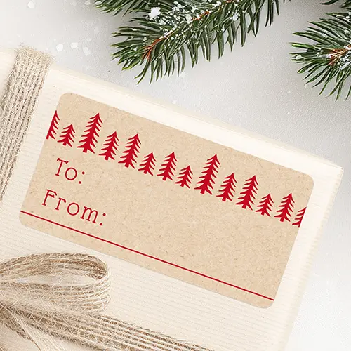 A horizontal rectangular self-adhesive gift tag sticker featuring a printed kraft paper texture. A row of red pine tree silhouettes lines the top edge, with red typewriter font reading To and From on the left, framed by a thin red line at the bottom.