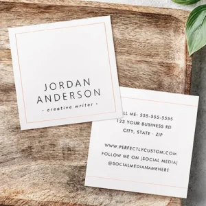 Modern square custom business card with metallic foil border accents. Front and back view of a square business card with a white background and thin real foil border framing. The front displays centered uppercase name text, and the back features structured contact information framed by horizontal foil header and footer stripes.
