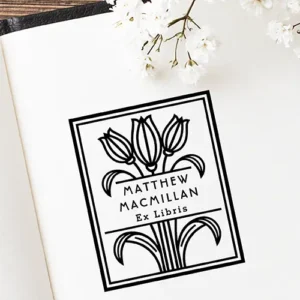 Rectangular wood-mounted rubber stamp featuring a geometric tulip illustration, double line border, and custom Ex Libris name typography. Vintage Art Deco style.