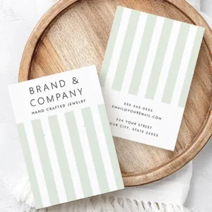 Double-sided earring display card displaying sage green vertical stripes, clean brand header typography, and rear contact text fields.