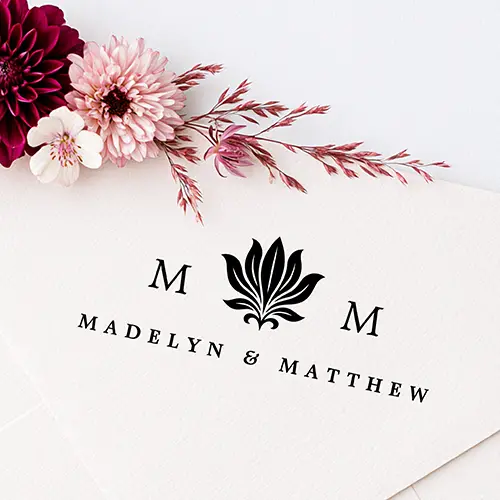 Rubber stamp design featuring a central stylized lotus flower leaf motif flanked by two serif initial letters and custom text centered below