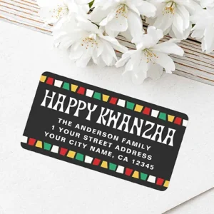 Rectangular Kwanzaa address label with colorful mosaic border A charcoal black rectangular sticker displaying white Happy Kwanzaa text, customizable family name and address lines, and top and bottom borders made of red, yellow, green, and white mosaic tiles.