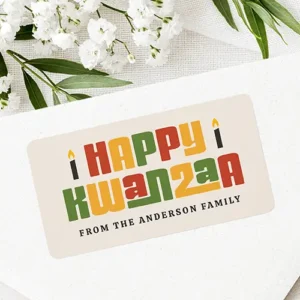 Happy Kwanzaa black candle custom name text Label Rectangular cream-colored sticker label featuring colorful red, green, and yellow Happy Kwanzaa block typography flanked by black candle icons above a custom family signature line.