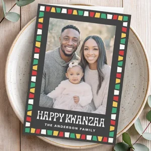 Happy Kwanzaa red green yellow mosaic border photo Holiday Card Vertical folded holiday greeting card featuring a central family photo surrounded by a black border with red, green, yellow, and white geometric mosaic tiles and text reading Happy Kwanzaa.