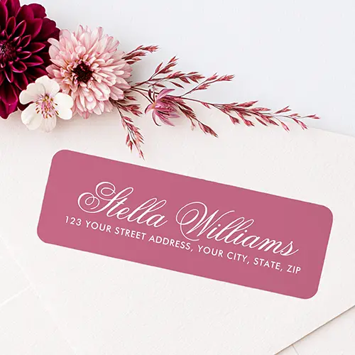 Rectangular dusty rose return address label sticker with rounded corners featuring a white calligraphy script name line above a white sans-serif address line.