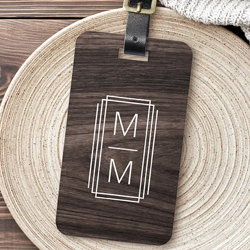 A rectangular dark espresso wood grain luggage tag with rounded corners, featuring a white triple geometric frame enclosing stacked custom initials, attached with a leather strap.