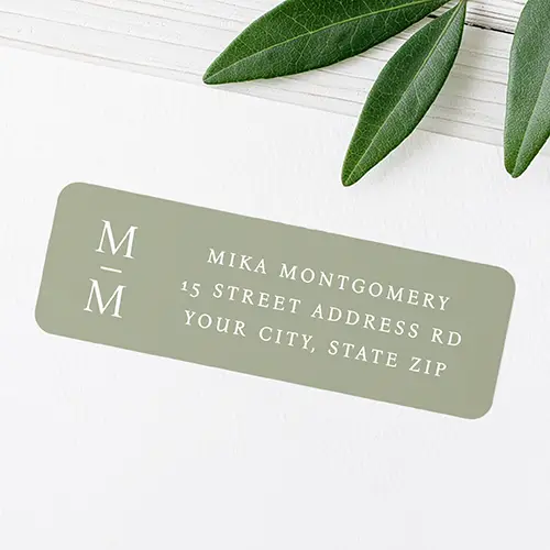 A rectangular return address label featuring a muted sage green background, a left-aligned stacked white monogram, and three lines of address text on the right.